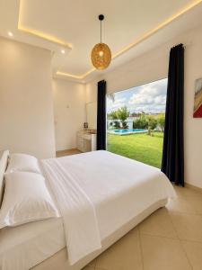 a bedroom with a large white bed and a large window at Luxury Villa with Pool & Garden5km from Cabo in Tétouan +30 photos