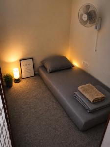 a bed in a room with a fan at The Cozy Cube in Rawalpindi +11 photos
