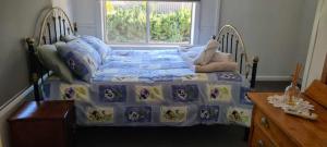 a bedroom with a bed with a teddy bear on it at Mimis Cottage in Cohuna