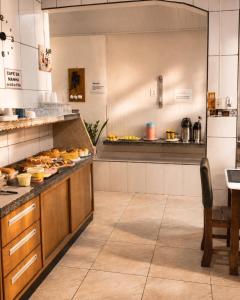 a kitchen with a counter with food on it at Caliani Hotel in Espigão dʼOeste