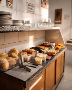a buffet line with many different types of bread and pastries at Caliani Hotel in Espigão dʼOeste