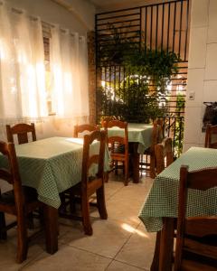 a restaurant with two tables and chairs with green table cloth at Caliani Hotel in Espigão dʼOeste