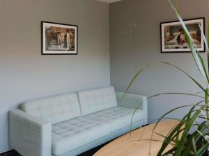 a living room with a white couch and a table at ibis Brussels Waterloo in Waterloo