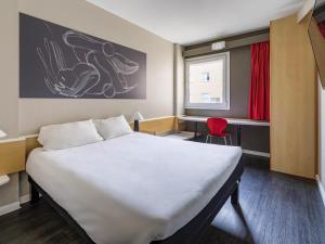 a bedroom with a large white bed in a room at Ibis Madrid Getafe in Getafe