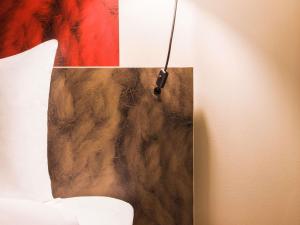 a painting hanging on a wall next to a bed at ibis Winterthur City in Winterthur