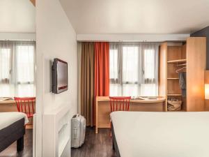 a hotel room with a bed and a desk at ibis Paris Bastille Faubourg St Antoine in Paris +28 photos