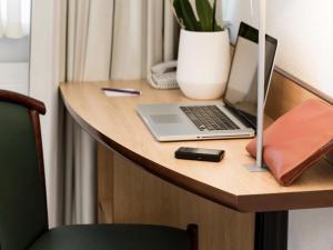 a desk with a laptop computer on a wooden table at Résidence Studio Genève Centre in Geneva