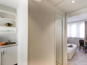 a room with white walls and a door with a mirror at Résidence Studio Genève Centre in Geneva +13 photos