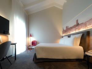 a hotel room with a bed and a tv at Mercure Bergamo Centro Palazzo Dolci in Bergamo