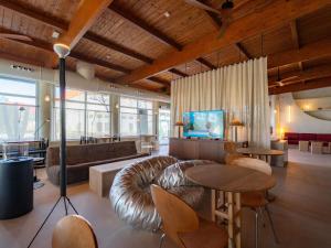 a living room with a leather couch and tables at Ibis Valencia Alfafar in Alfafar +53 photos