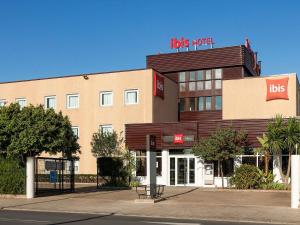 a building with a bus stop in front of it at Ibis Valencia Alfafar in Alfafar