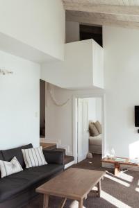 a living room with a black couch and a table at Circular Bay in Awaroa