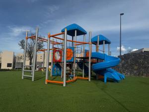 a playground with a slide on a grass field at Un escape moderno dentro de Zibatá in San Vicente Ferrer