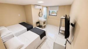 a hotel room with two beds and a television at Made Hotel in São Luís