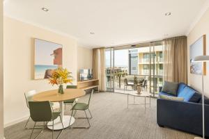 a living room with a table and a couch at Quest Scarborough in Perth