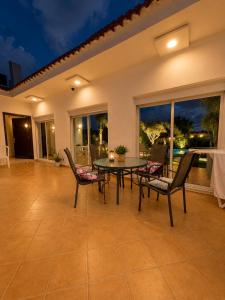 a dining room with a table and chairs on a patio at Luxury Villa with Pool & Garden5km from Cabo in Tétouan