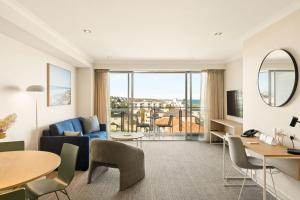 a living room with a couch and a table at Quest Scarborough in Perth