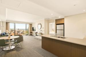 a kitchen and living room with a table and chairs at Quest Scarborough in Perth