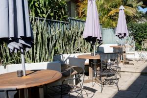 a group of tables and chairs with umbrellas at Heritage On Horseshoe Guest House in South West Rocks