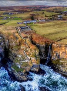 an aerial view of a waterfall on a cliff at Harbour bridge, Camps bar in Wick