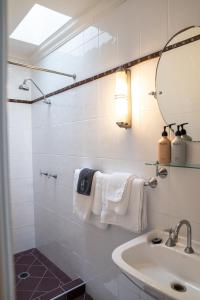 a bathroom with a sink and a mirror and towels at Heritage On Horseshoe Guest House in South West Rocks