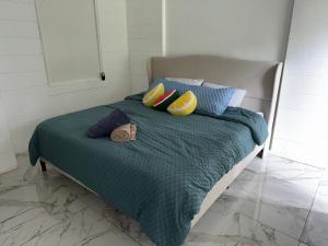 a bed with a green comforter and colorful pillows at Studio sunshine in St. Petersburg +4 photos