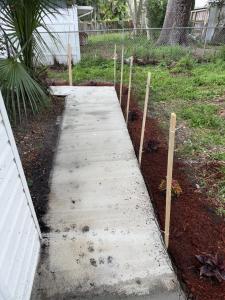 a concrete walkway in a garden with a fence at Studio sunshine in St. Petersburg