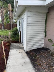 a white garage next to a house at Studio sunshine in St. Petersburg