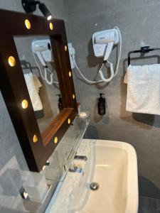 a bathroom with a sink with a mirror and a hair dryer at Trump House in Anuradhapura +49 photos