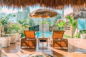 two chairs and an umbrella and a pool at La Palapa Inn Port Barton in San Vicente
