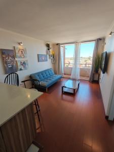 a living room with a blue couch and a table at Hermoso y cómodo departamento en edificio in Calama