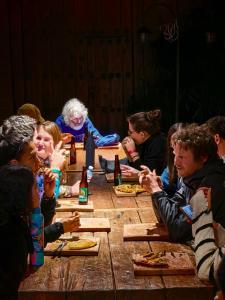 a group of people sitting around a wooden table at Puerta Vieja Hostel in San Cristóbal de Las Casas +93 photos
