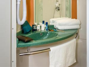 a bathroom with a green sink and a mirror at ibis La Bresse Gérardmer in La Bresse +119 photos