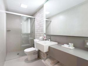 a bathroom with a sink and a toilet and a shower at Mercure Sao Paulo Paulista in São Paulo