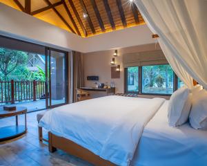 a bedroom with a large bed and a balcony at H Resort Bohol - The Coral Cliff by SMS Hospitality in Calape +107 photos