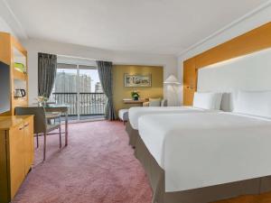 a hotel room with two beds and a desk at Sofitel Cairo Nile El Gezirah in Cairo