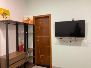 a flat screen tv hanging on a wall at Lindo APTO bem localizado em Sinop! in Sinop