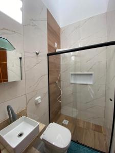 a bathroom with a toilet and a sink and a shower at Lindo APTO bem localizado em Sinop! in Sinop +21 photos