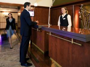 a man and a woman standing at a cash register at Mercure Grand Hotel Biedermeier Wien in Vienna