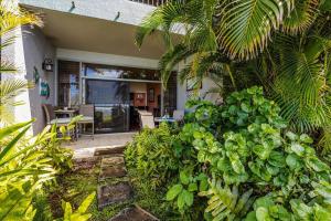 a house with a garden and a patio at Hale Mahina A102 in Kahana