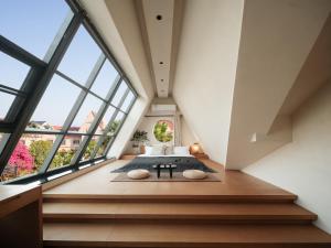 an attic bedroom with a bed and large windows at Silver Beach Yuese Hostel in Beihai
