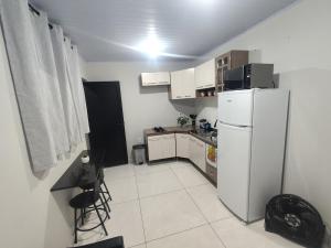 a small kitchen with a white refrigerator and a table at Gk-Hospedagem in Foz do Iguaçu +25 photos