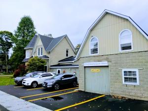 a house with cars parked in a parking lot at Granary Guest House in Goderich