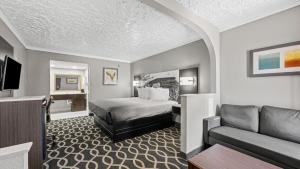 a hotel room with a bed and a couch at Super 8 by Wyndham Norman West OK in Norman