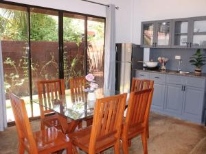a dining room with a glass table and four chairs at Villa Flora Bella Yellow Bell in Dauis