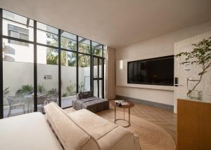 a living room with a couch and a flat screen tv at Silver Beach Yuese Hostel in Beihai