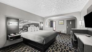 a hotel room with a bed and a flat screen tv at Super 8 by Wyndham Norman West OK in Norman