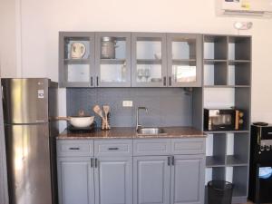a kitchen with white cabinets and a stainless steel refrigerator at Villa Flora Bella Yellow Bell in Dauis