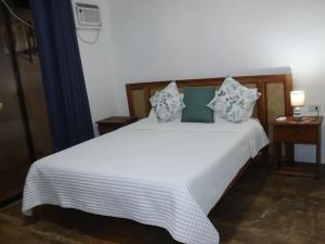 a bedroom with a white bed with blue and white pillows at Villa Flora Bella Yellow Bell in Dauis +18 photos