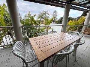 a wooden table and chairs on a balcony at Jubilee Apartment 05 - Bring your own linen in South West Rocks